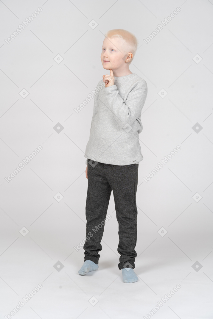 Three quarter view of a dreamy little boy looking up