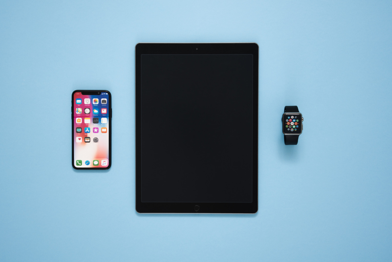 Digital tablet, smartphone and smartwatch over blue background