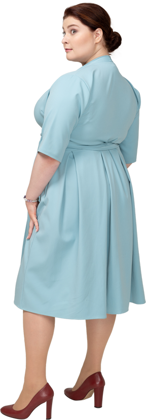 Вид сзади женщины в синем платье
