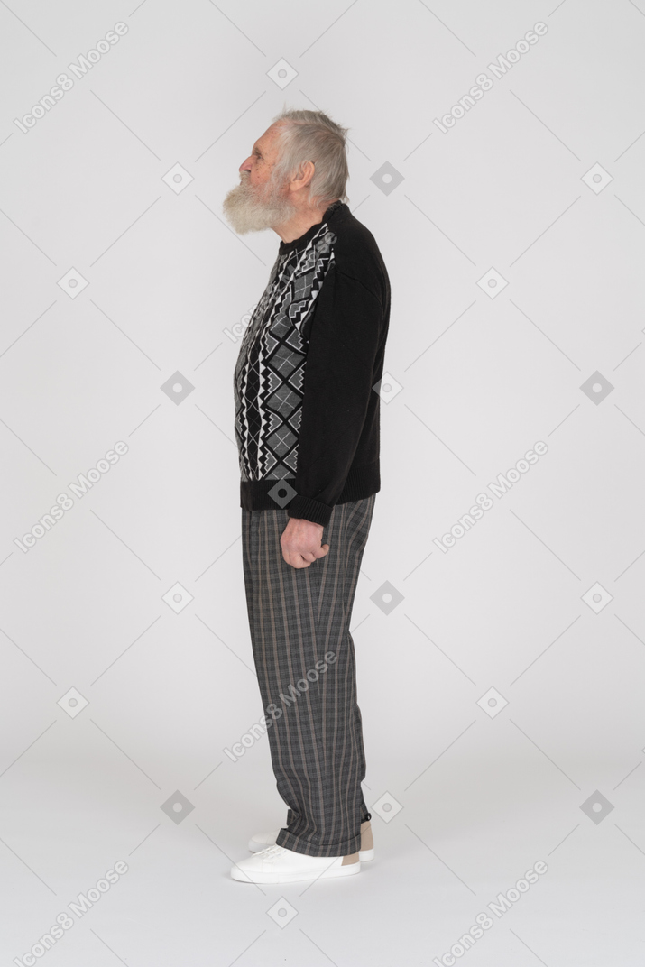 Vista lateral de un anciano de pie y haciendo una mueca