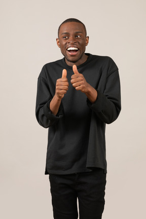 Young man showing thumbs up and smiling