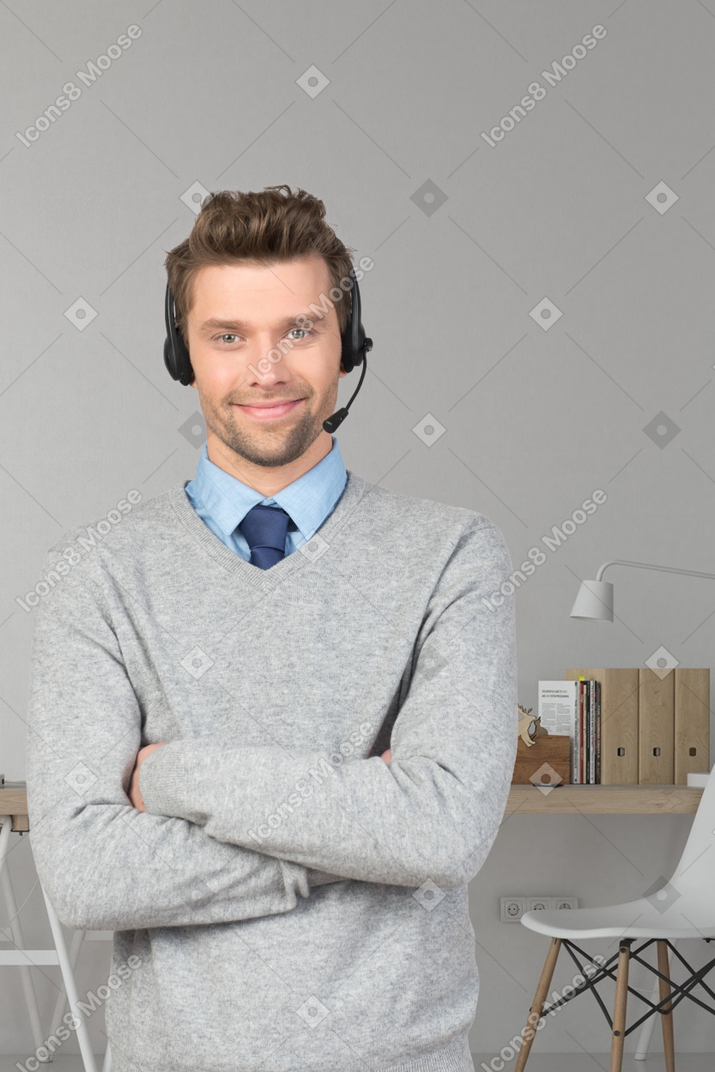 A man wearing a headset standing in front of a desk