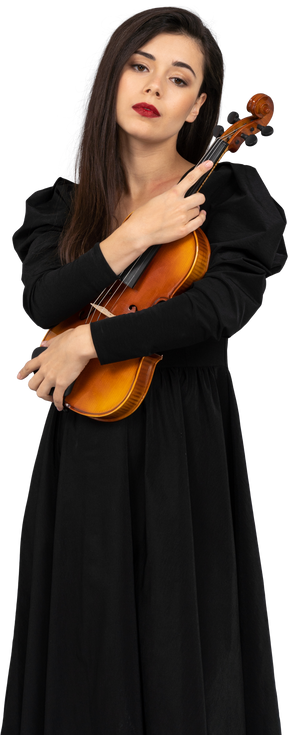 Вид спереди молодой леди в черном платье, держащей скрипку