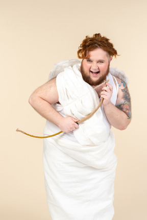 Laughing big guy dressed as a cupid holding bow