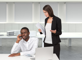 A woman talking to a man while man talking on the phone