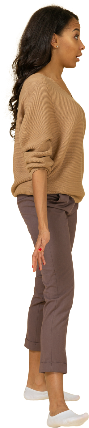 Vista lateral de una mujer joven de piel oscura cuestionando extendiendo sus manos