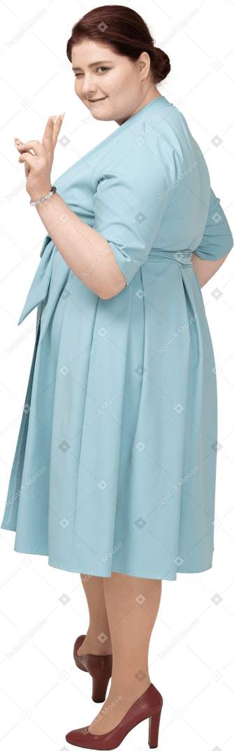 一个穿着蓝色裙子的女人的侧视图，显示 v 标志