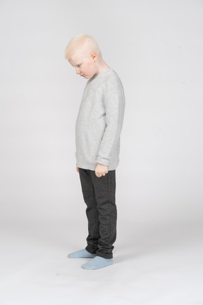 Little boy standing and looking down