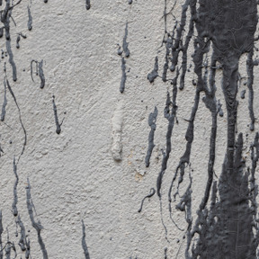 검은 페인트 반점이 있는 회색 석고 벽
