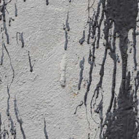 Pared de yeso gris con manchas de pintura negra