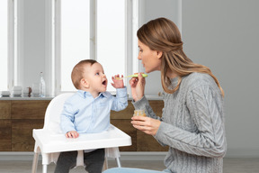 Woman feeding a baby with spoon