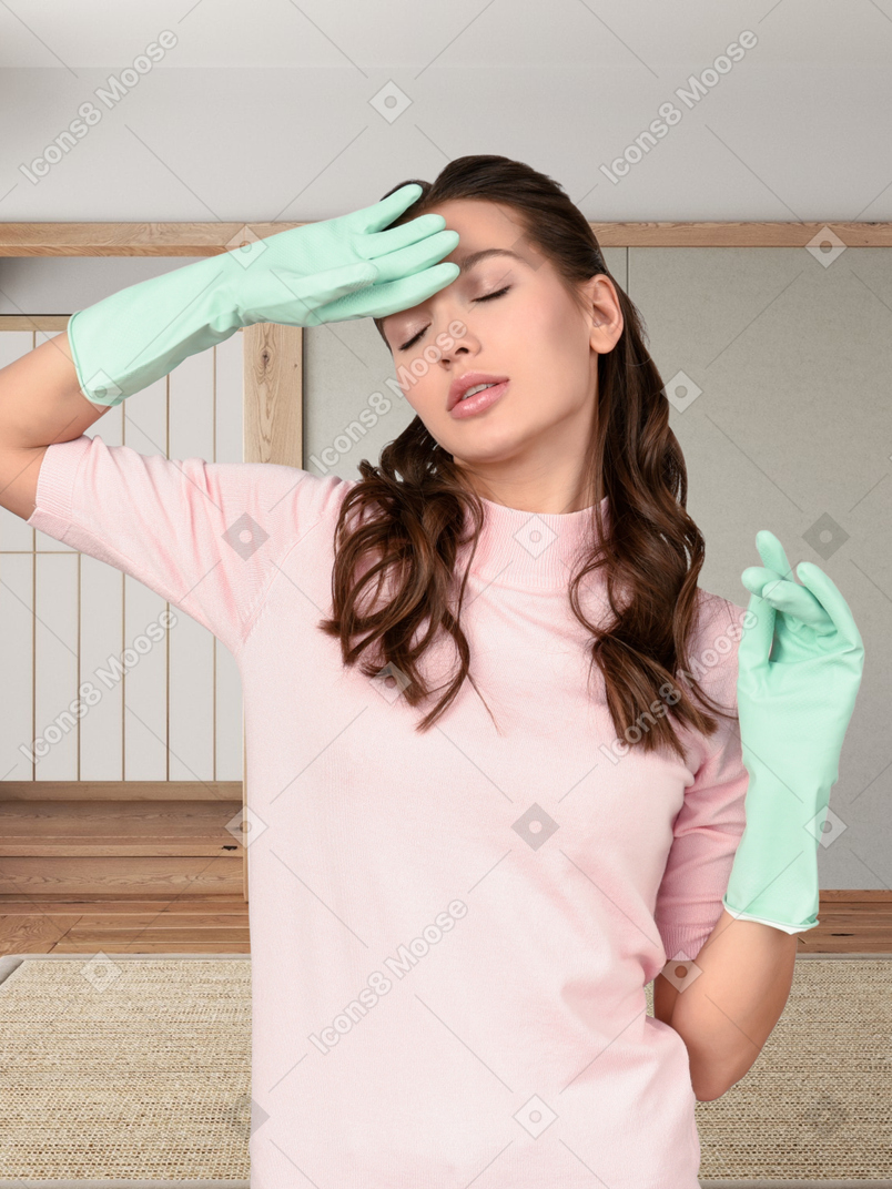 A woman in a pink shirt and green gloves