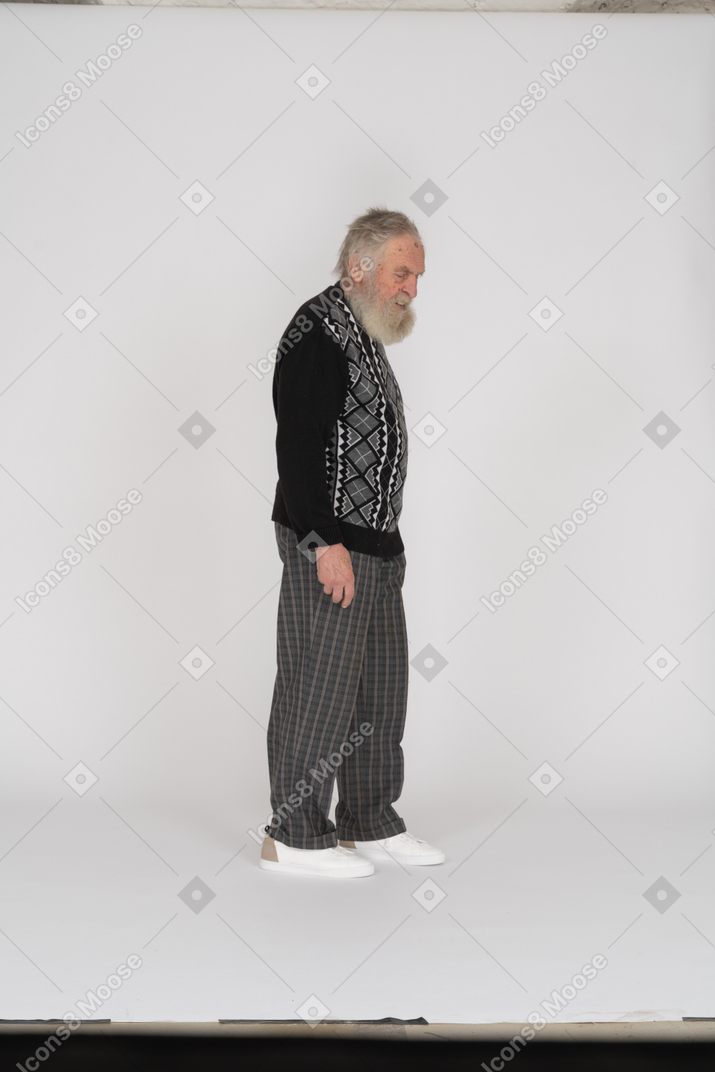 Vista lateral de um homem idoso de pé e olhando para baixo