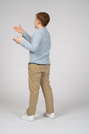 Back view of a boy gesturing with his hands
