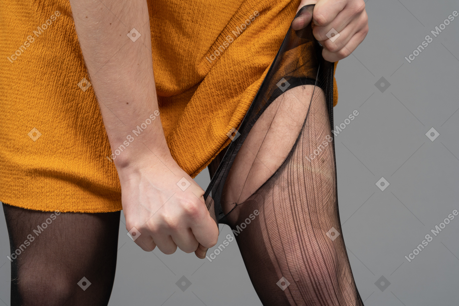Foto recortada de uma pessoa em vestido laranja rasgando meia-calça
