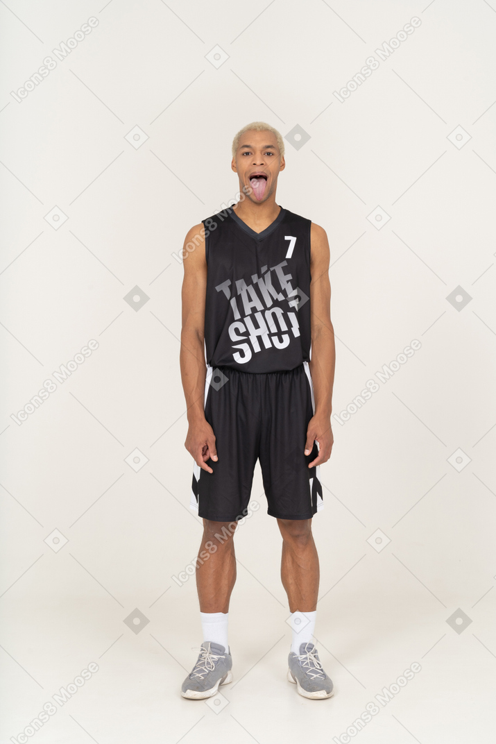 一个疯狂的年轻男篮球运动员展示舌头的前视图