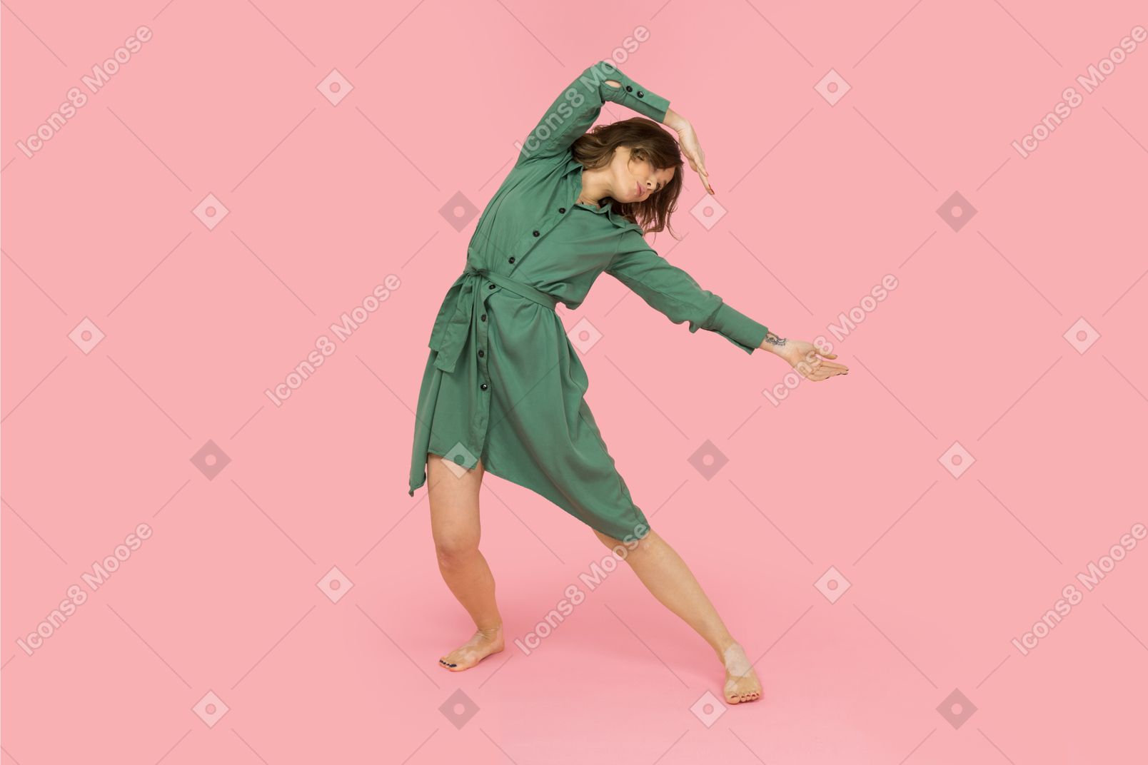 Femmina in abito verde che balla da sola