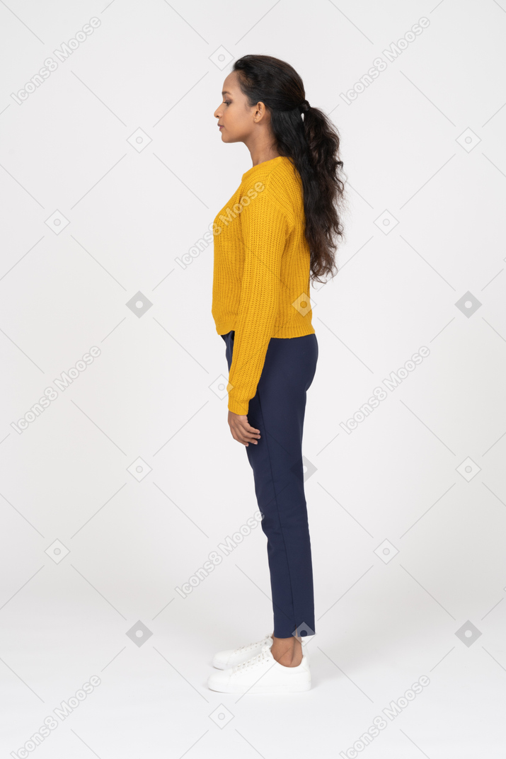 Linda garota com roupas casuais em pé em seu perfil