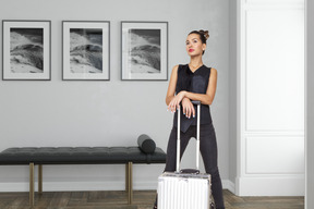A woman standing with a suitcase in a room