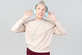 Old lady in listening music in headphones