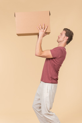 Delivery guy standing in profile and putting a parcel up