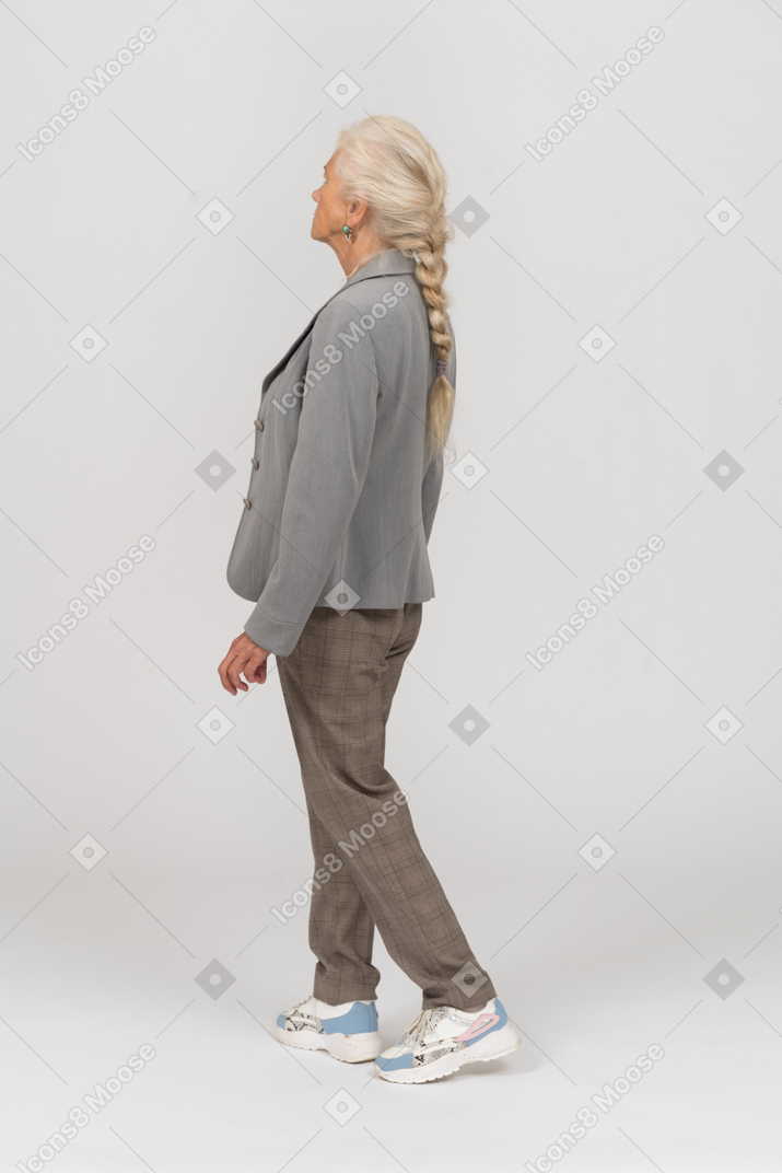 Side view of an old lady in suit walking