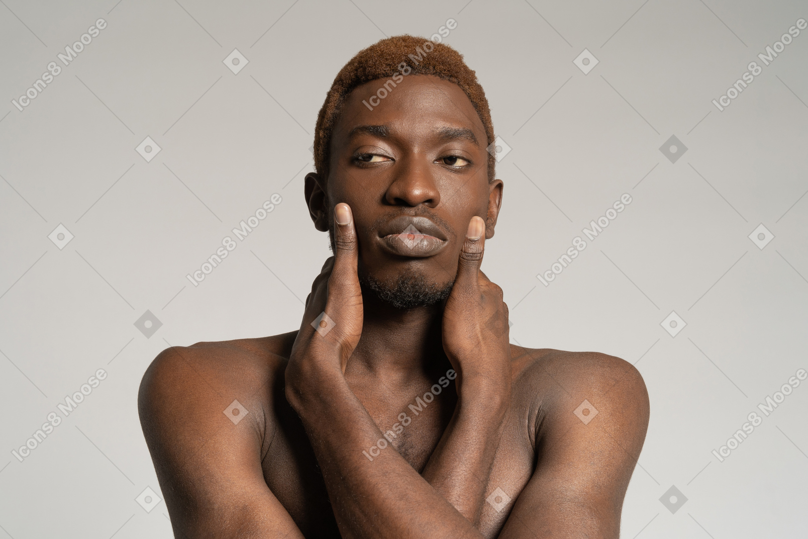 Portrait of young man touching face with both hands
