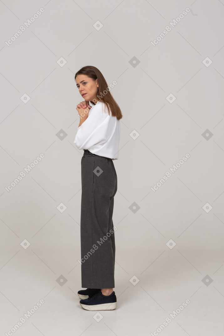Vista frontal de uma jovem com roupa de escritório, olhando para a câmera