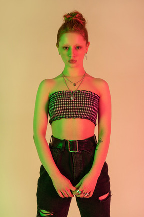 Close-up de uma adolescente feminina de top curto e jeans em neon