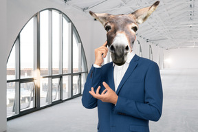 Man with donkey head in suit talking on the phone
