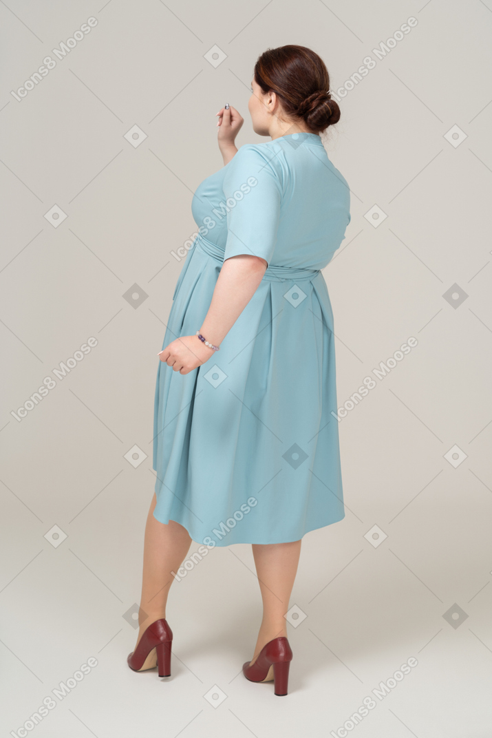 Retrovisor de uma mulher de vestido azul caminhando