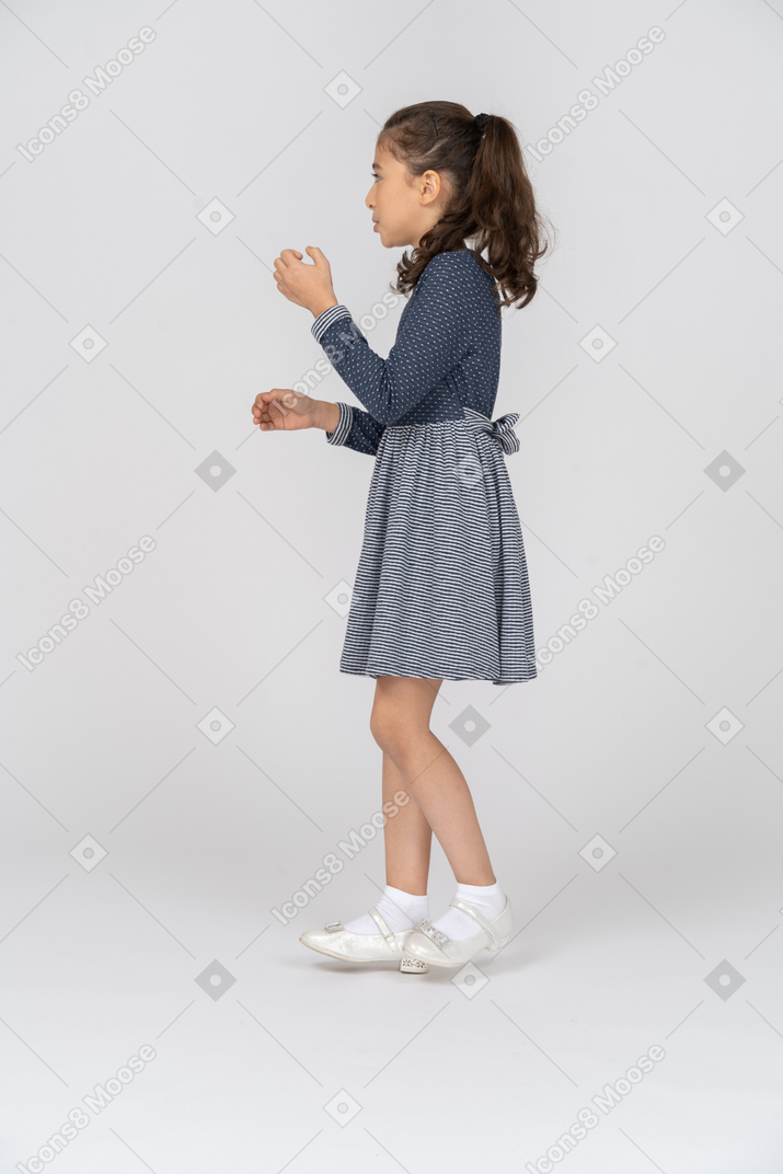 Vista lateral de una niña retrocediendo en movimiento
