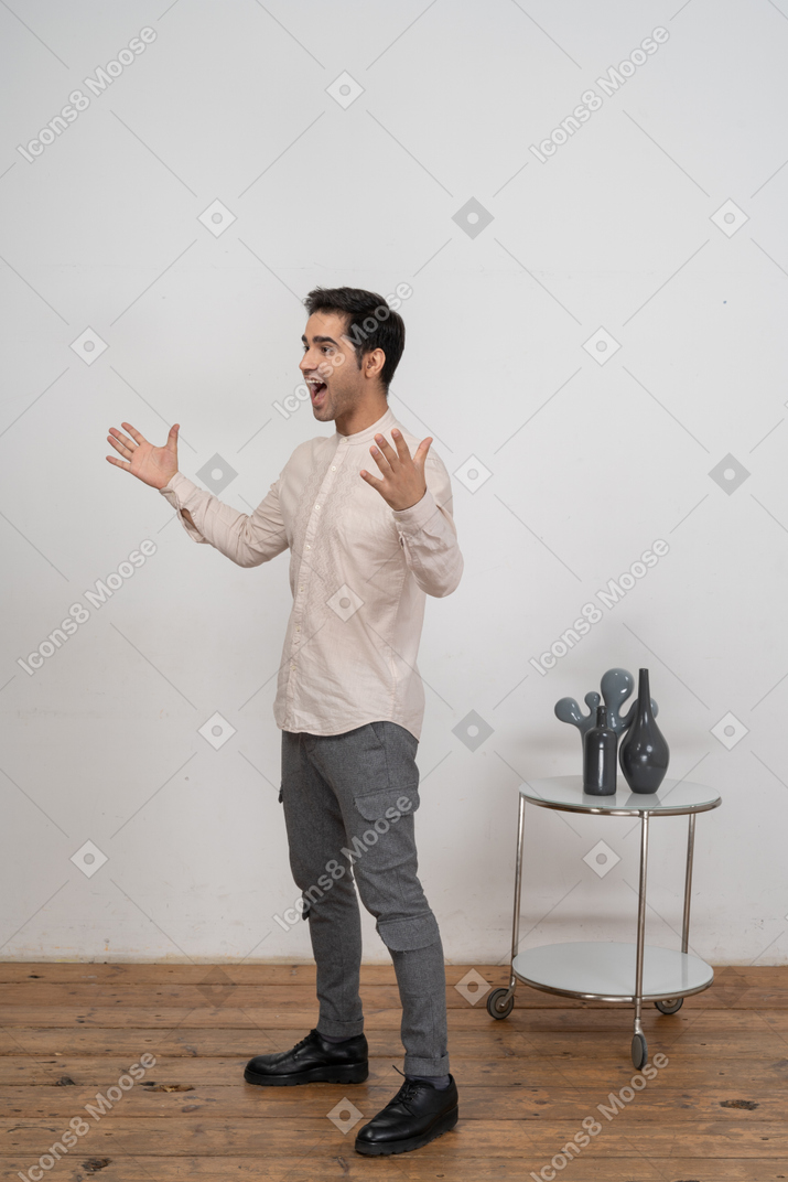 Vista lateral de um homem feliz em roupas casuais gesticulando