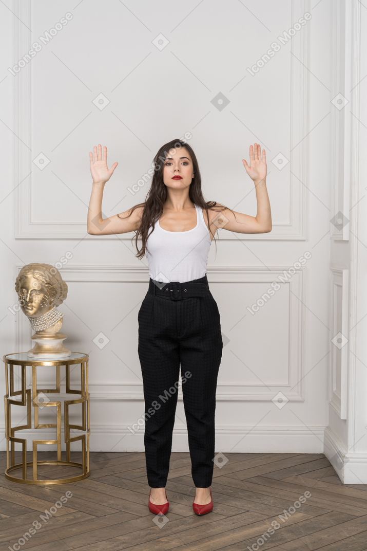 Front view of young businesswoman raising hands