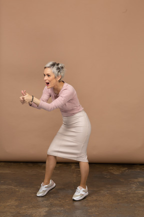 Вид спереди эмоциональной женщины в повседневной одежде, показывающей большие пальцы вверх