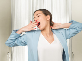 A woman in suit yawning