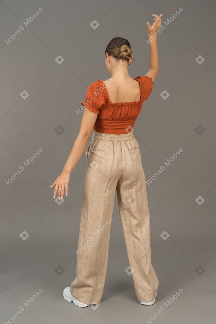 Back view of young woman pretending to throw someyhing