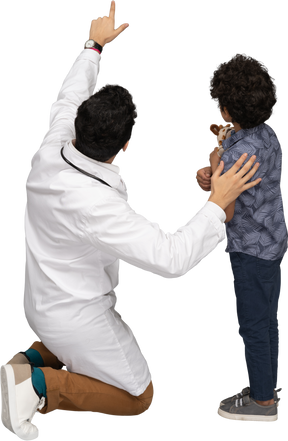 Médico mostrando algo para menino