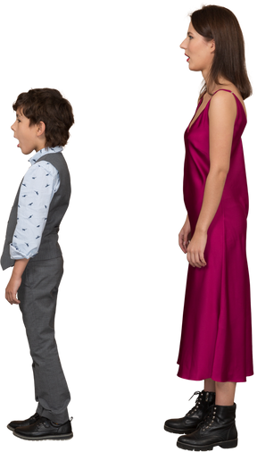 Femme en robe rouge et petit garçon debout de profil