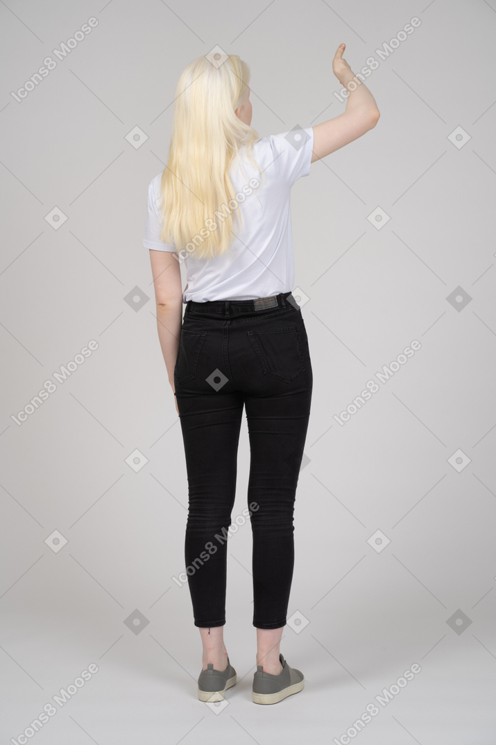 Back view of girl standing wit raised hand