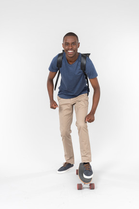 City male tourist standing on skateboard