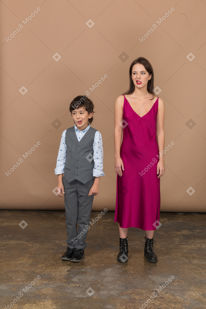 Vista frontal de um menino e uma mulher sorrindo com um vestido vermelho