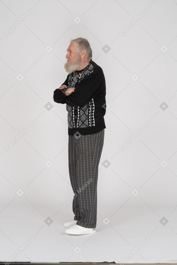 Side view of old man standing with arms crossed