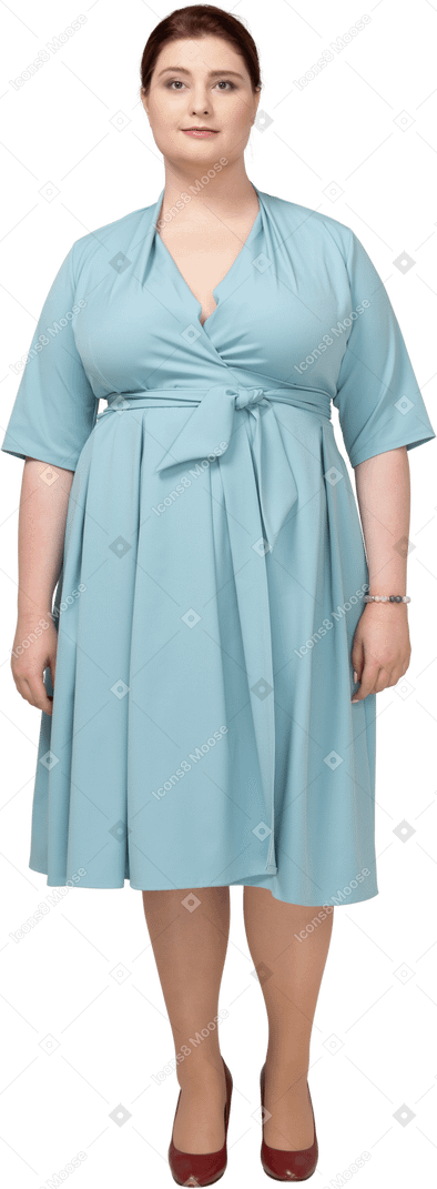 Vista frontal de uma mulher de vestido azul olhando para a câmera