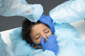 Médico colocando a máscara de oxigênio na criança