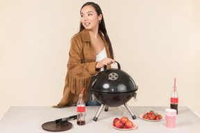 Young asian woman standing near closed grill
