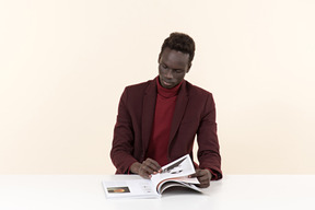 Elegante homem negro sentado à mesa no escritório