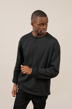 Young man standing with clenched fist and looking away from camera