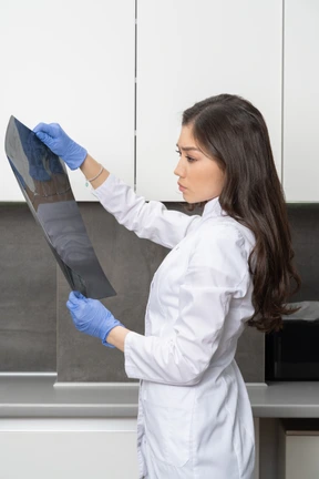 Side view of a thoughtful female doctor analyzing x-ray image