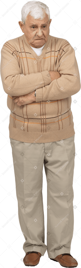 Front view of a grumpy old man in casual clothes standing with crossed arms